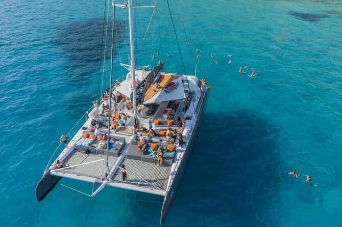 Balade en catamaran sur la lagune turquoise de Dakhla avec flamants roses en arrière-plan, Maroc